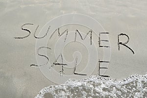 Summer sale written in the sand